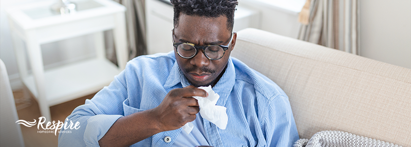 Man sneezing and holding tissue