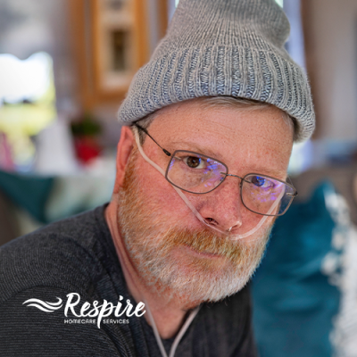 Man in a winter hat with oxygen tubes in his nose