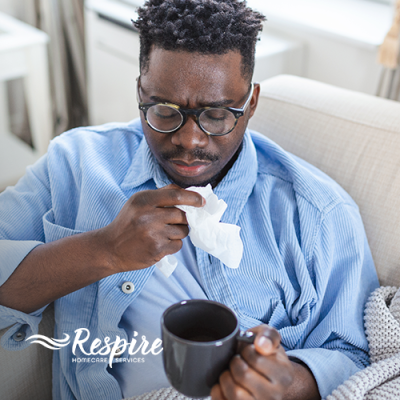 Man sneezing and holding tissue
