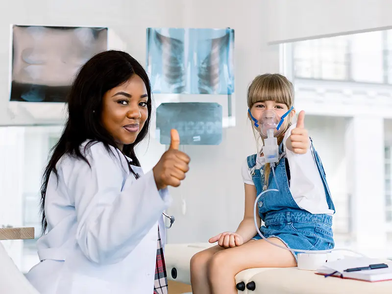 nurse with girl patient giving thumbs up